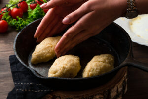 women's hands making cutlets on pan